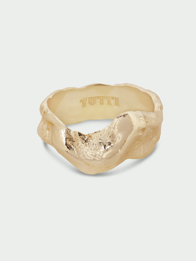 Tutti & Co Forge Ring in Gold A gold-toned ring with an organic, textured, wavy shape and a polished interior engraved with the brand name 'TUTTI', shown on a light gray background.