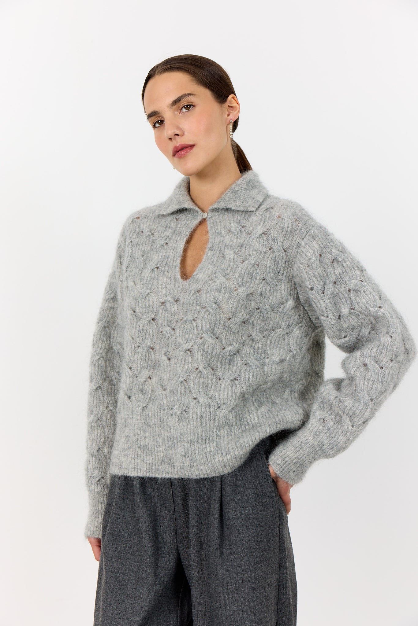 Levete Room Niva 1 Pullover in Light Grey Woman wearing a gray cable knit sweater with a cutout design on a white background