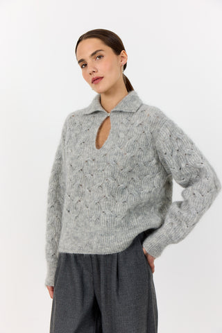Levete Room Niva 1 Pullover in Light Grey Woman wearing a gray cable knit sweater with a cutout design on a white background
