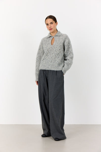 Levete Room Niva 1 Pullover in Light Grey Woman wearing a gray sweater and wide-leg pants against a white background