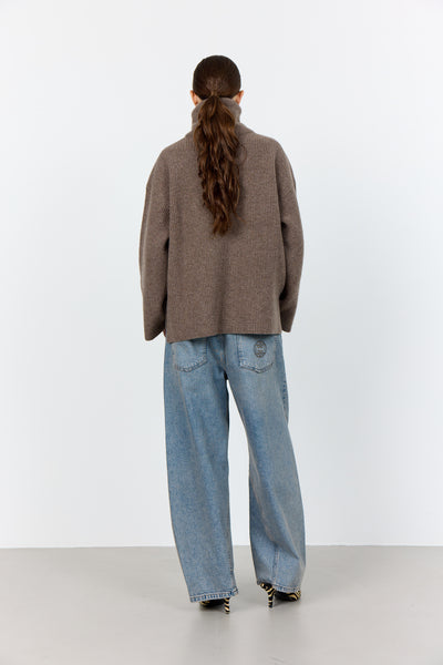 Levete Room Perle 10 Pullover in Walnut Melan Person wearing a brown sweater and blue jeans from behind on a white background