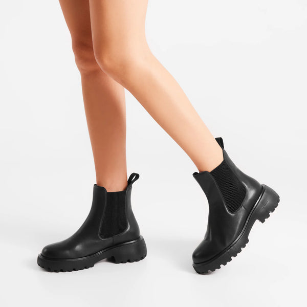Woden Aya L Boots in Black Black Chelsea boots worn by a person on a white background