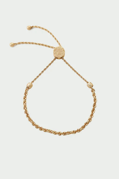Tutti Freedom Bracelet in Gold Gold bracelet on a light beige background
