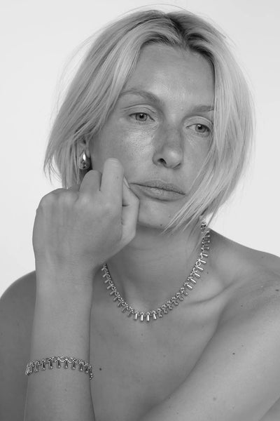 Tutti Dewdrop Necklace in Silver Black and white portrait of a person wearing jewelry with a plain background
