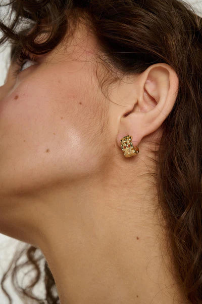 Tutti Linear Earrings in Gold Close-up of an ear wearing a gold earring with a blurred background