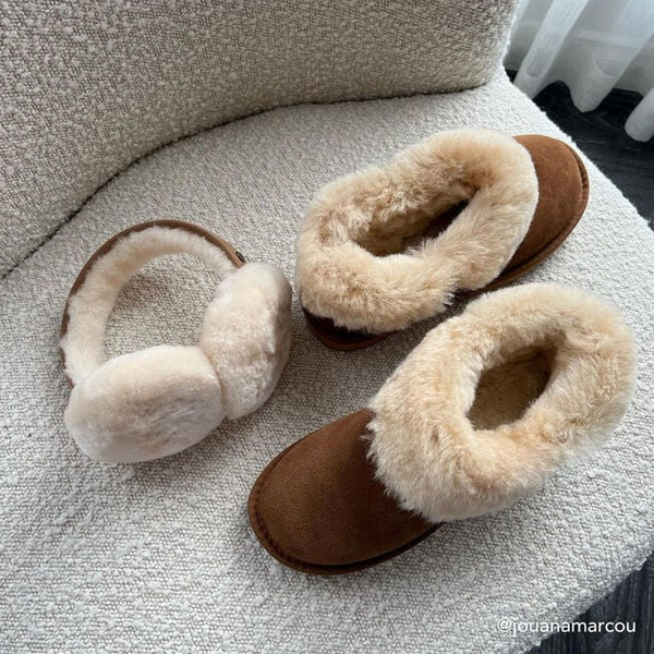 Emu Australia Angahook Earmuffs in Chestnut W9403 Pair of beige slippers with brown soles on a textured surface