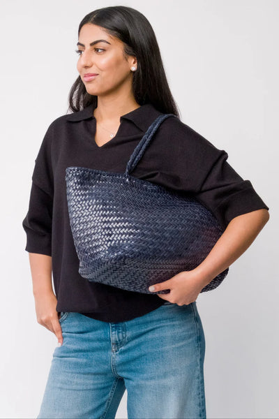 Ellyla Amora Woven Shoulder Bag in Dark Blue Woman holding a woven blue bag against a plain background