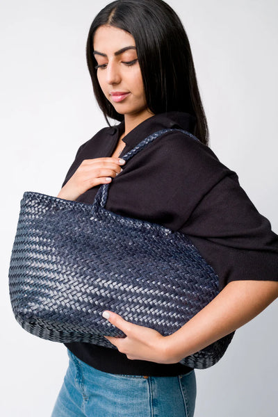 Ellyla Amora Woven Shoulder Bag in Dark Blue Woman holding a woven blue bag against a plain background