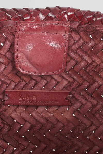 Ellyla Amora Woven Shoulder Bag in Burgundy Close-up of a red woven handbag with a visible brand label.