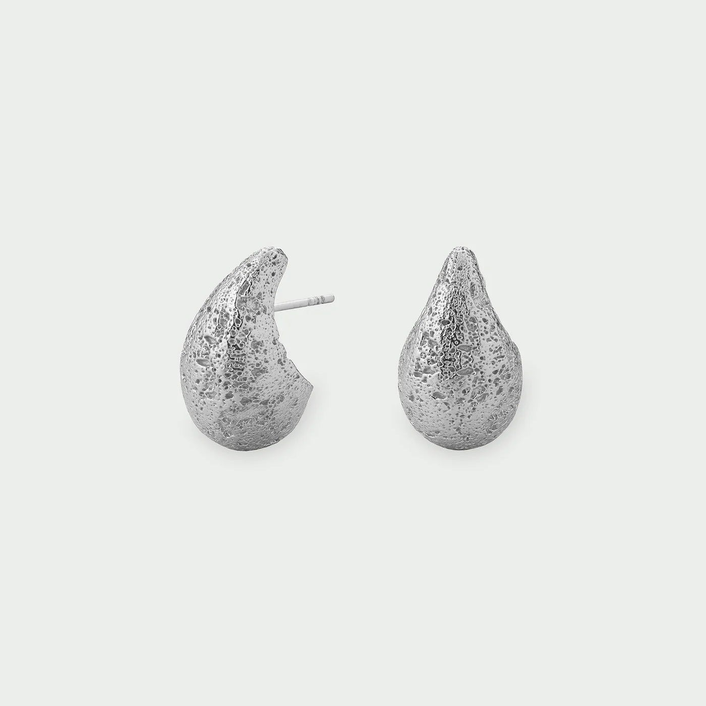 Tutti Small Dome Earrings in Silver Pair of silver teardrop-shaped earrings on a light gray background