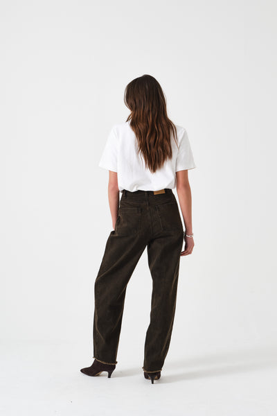 Seventy + Mochi Bo Jean in Cacao Short WBOJ0114-S Person wearing brown pants and a white shirt on a white background
