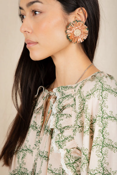 Bonte Florette Top in Clover Woman wearing a floral earring and a patterned blouse against a neutral background