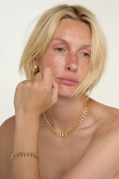 Tutti Dewdrop Necklace in Gold Woman wearing gold jewelry including earrings, necklace, and bracelet against a white background