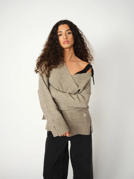 Heyanno Zen Tile Knit in Grey Melange Woman wearing a beige knitted cardigan over a black top against a white background